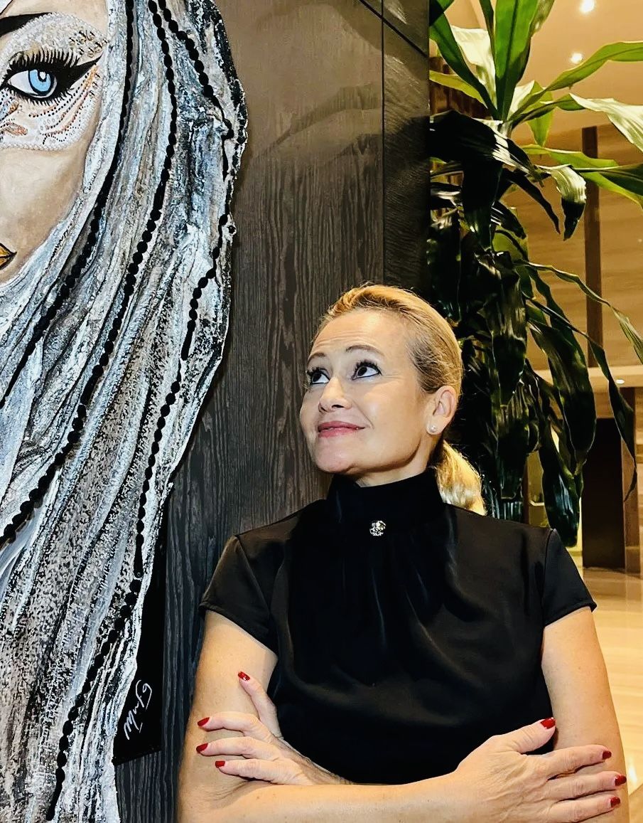Mfergó beside her artwork